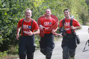 Three emergency service workers walking in Heli Hike