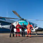 KSS crew standing in front of the helicopter.