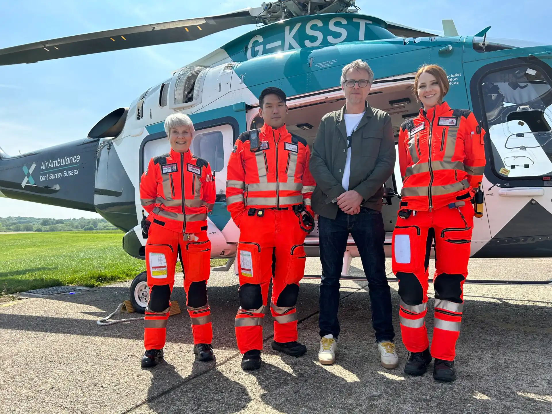 Rob Green, drummer with toploader, with members of Team KSS next to the helicopter
