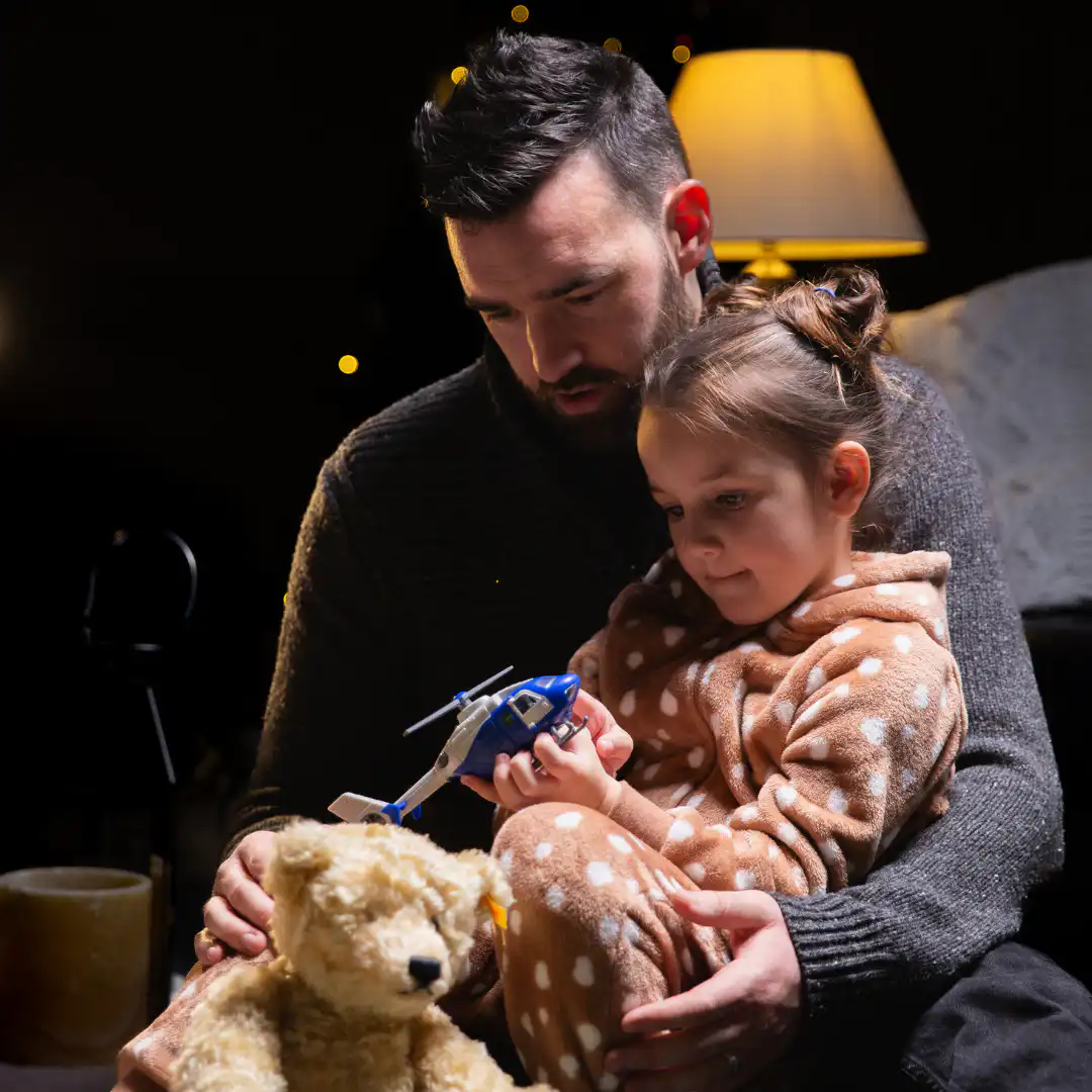 Paramedic Ben and his daughter playing with a toy helicopter
