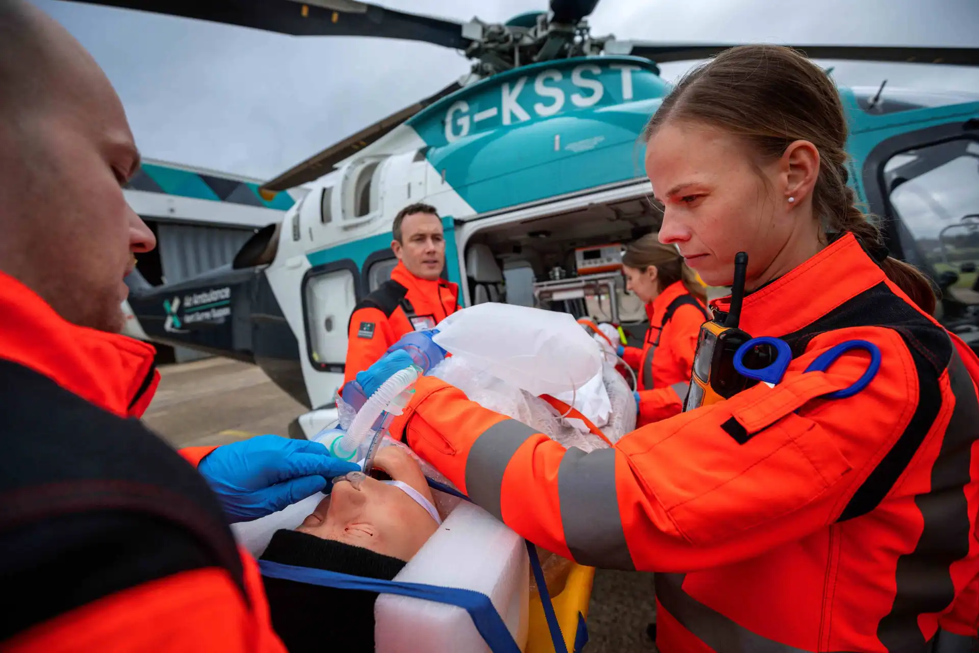 Air ambulance crew loading a patient on a stretcher onto a helicopter