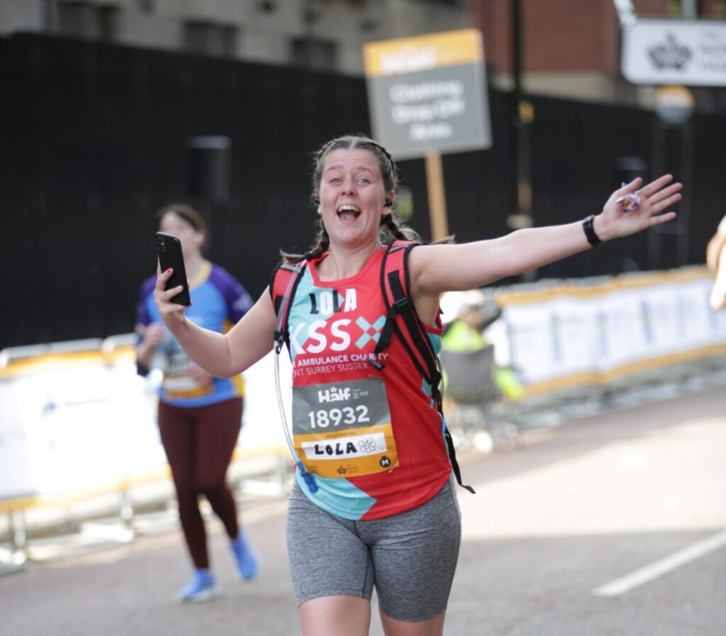 Lady running with arms out and wide smile.