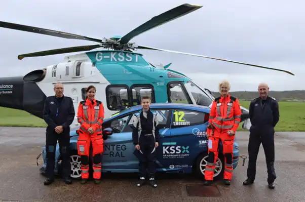Young racing driver Thomas Merritt and KSS crew with his car and KSS helicopter